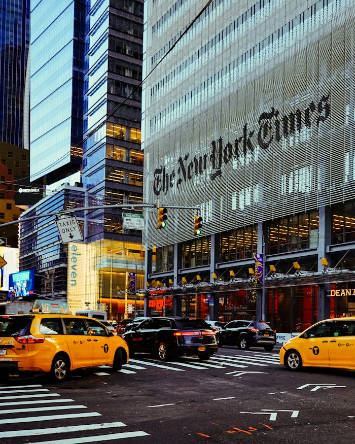Street view of the New York Times Building surrounded by taxis in bustling New York City.